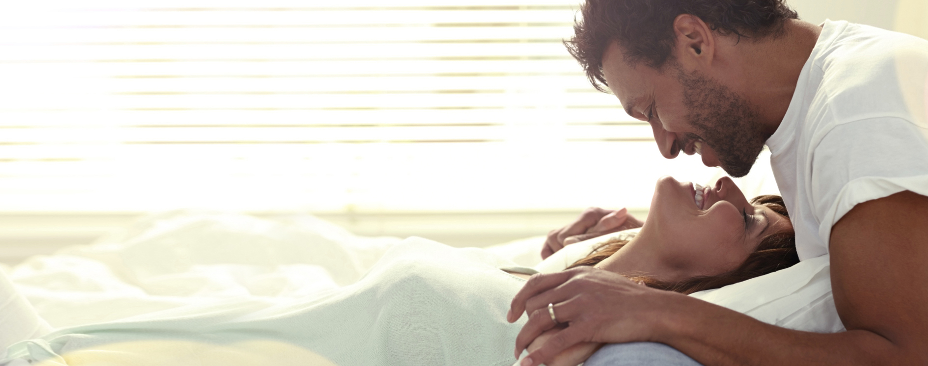 Immagine di un uomo e una donna sorridenti a letto